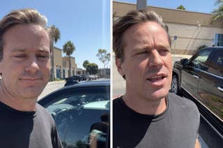 Armie Hammer standing outside near a parked car, wearing a casual black t-shirt, speaking and smiling with a building in the background