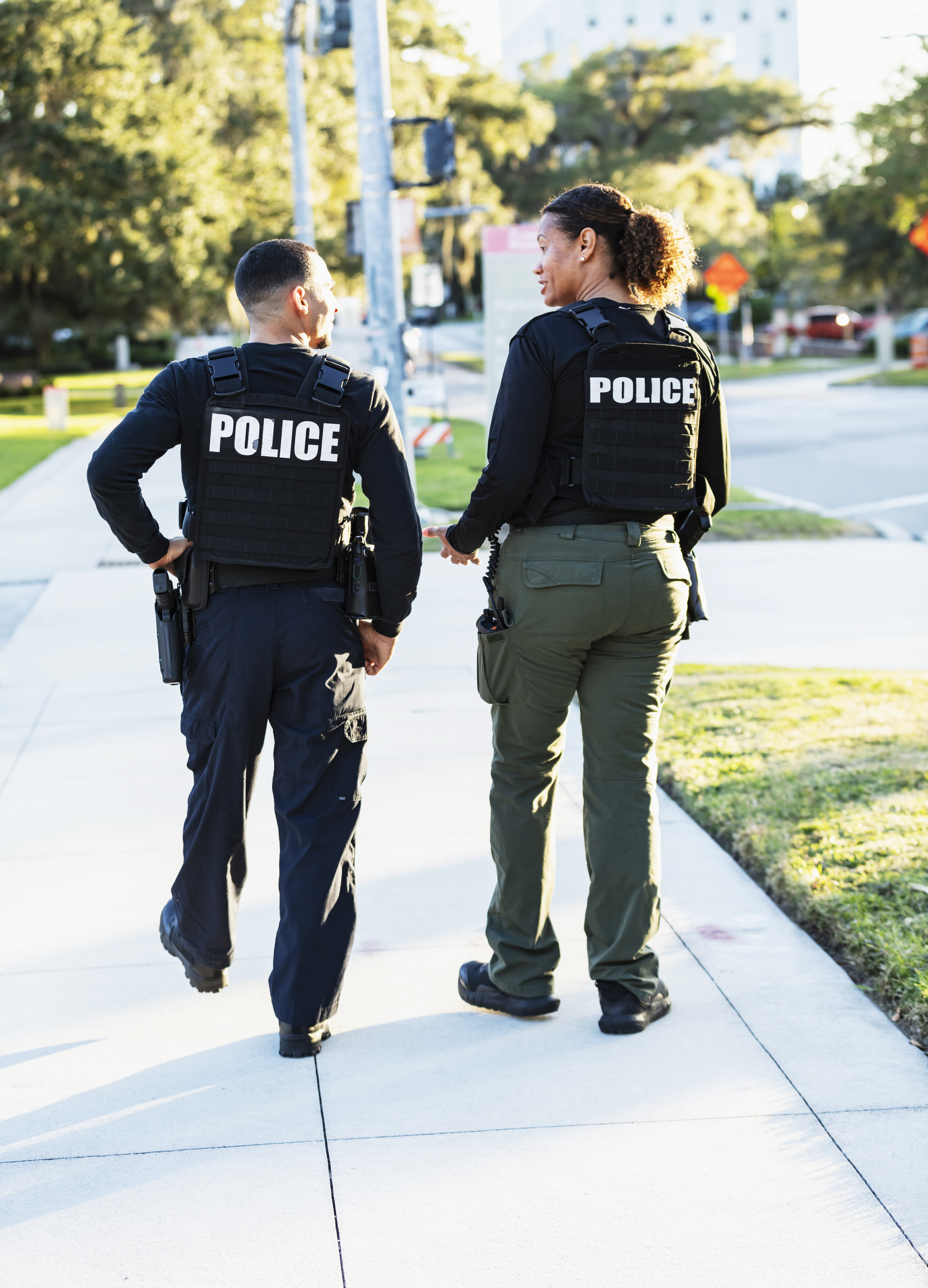 two police officers walking down a sidewalk