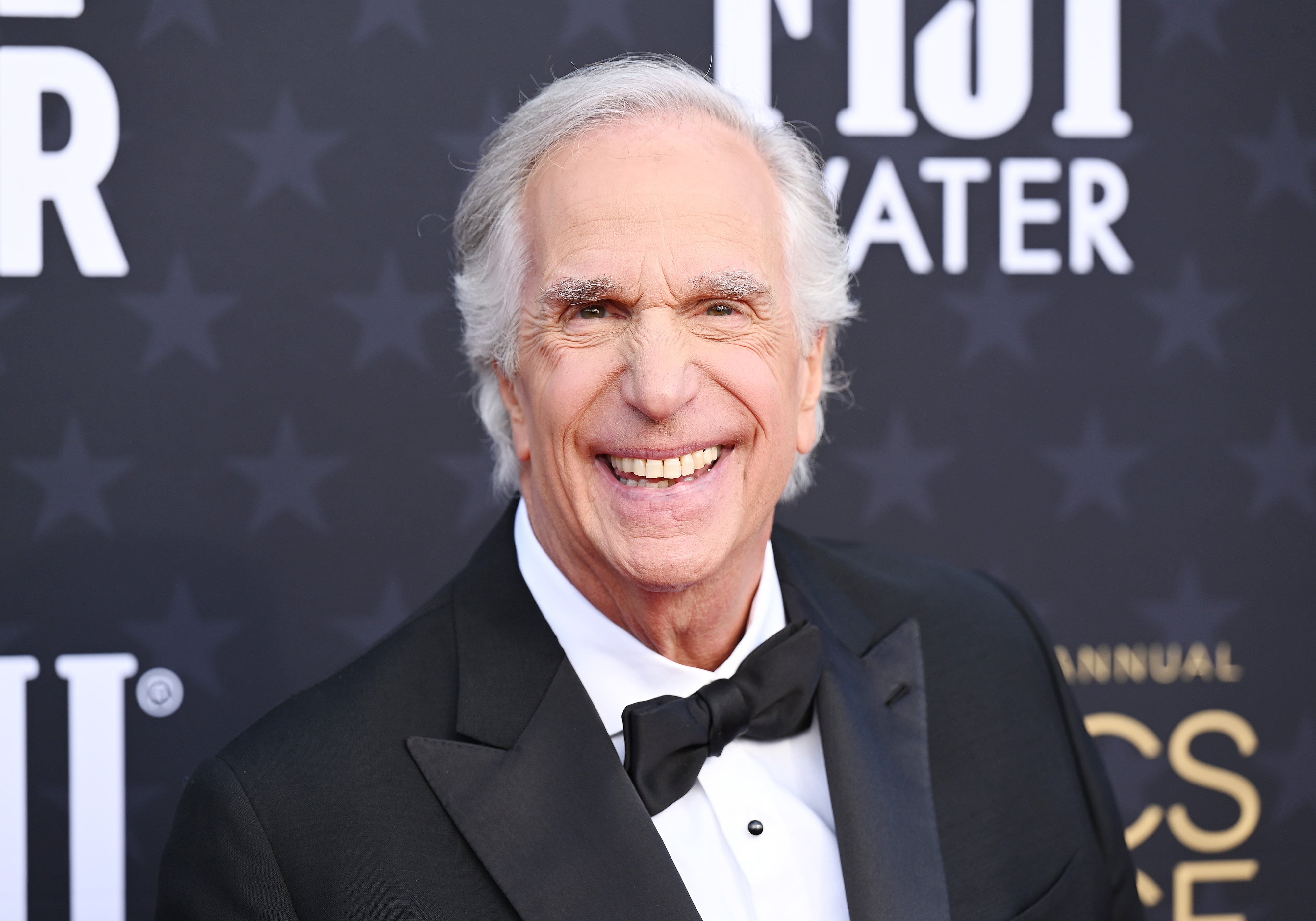 Person in a tuxedo smiling at a formal event