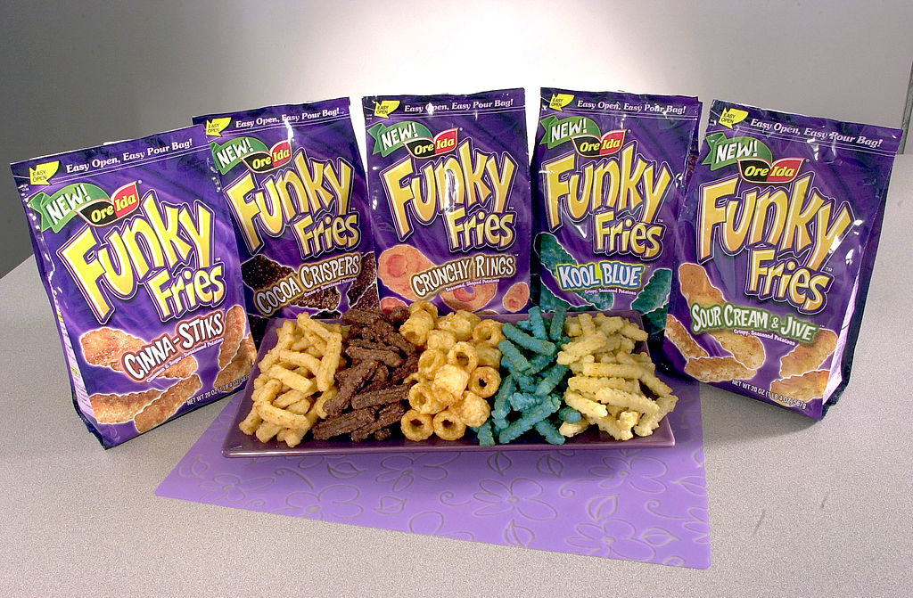 Bags of Funky Fries in various flavors, including Cinna-Stix, Cocoa Crispers, Crunchy Rings, Kool Blue, and Sour Cream &amp;amp; Jive, displayed on a tray