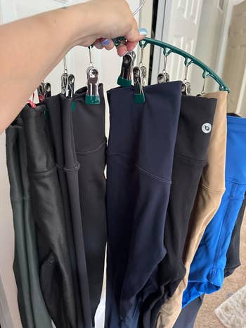 Various pairs of pants are clipped to a hanger, showcasing different styles and materials. This image is related to a shopping article