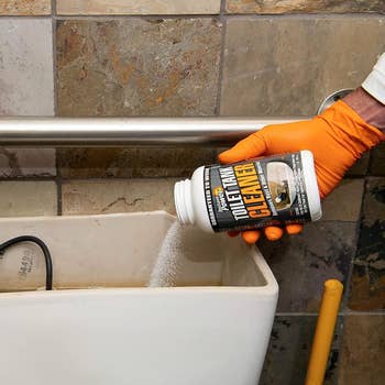 the toilet tank cleaning product being poured into a tank