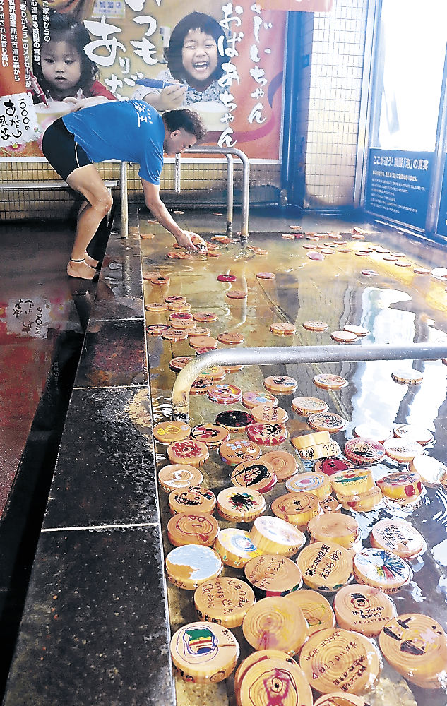 園児のメッセージが書かれたヒノキの入浴木を浮かべた風呂＝射水市鏡宮の天然温泉海王