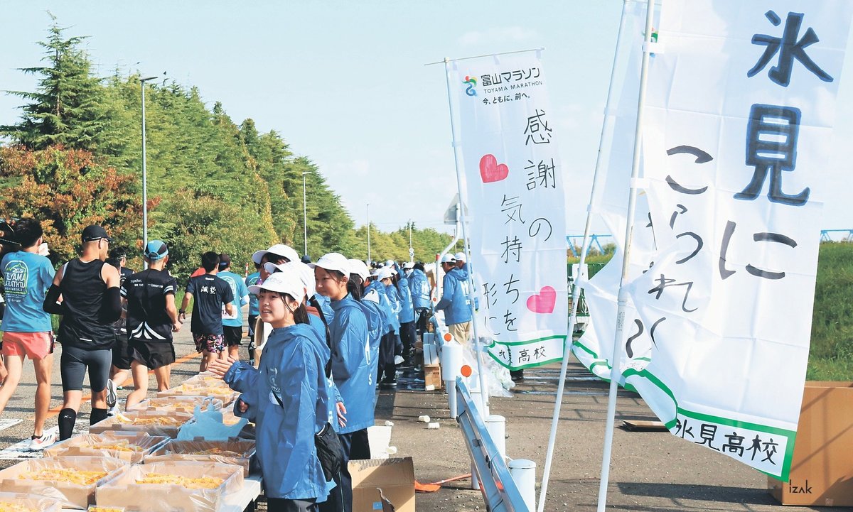 メッセージをしたためたのぼり旗の前でエールを送る氷見高生＝射水市庄西町２丁目