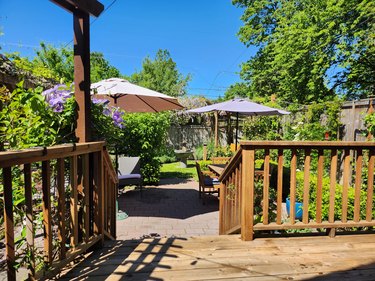 A succession of small garden rooms: a deck leading to a patio leading to a grassy lawn.