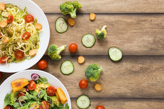 Cibo vegano su piatti bianchi con fondo in legno