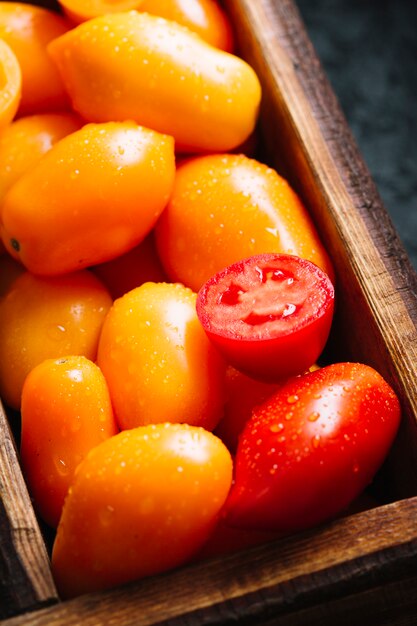 Piccoli pomodori arancio e rossi del primo piano