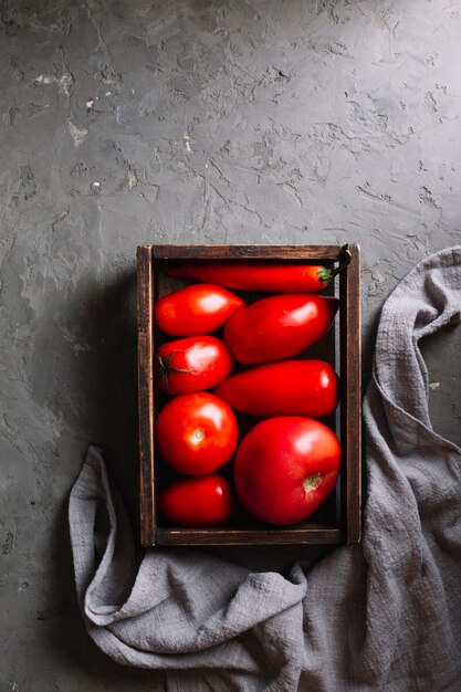 Pomodori rossi saporiti in una disposizione piana del cestino