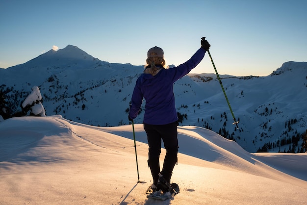 La ragazza avventurosa si sta godendo il paesaggio della montagna durante un tramonto vibrante