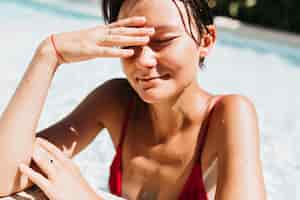 Foto gratuita modello femminile dai capelli corti attraente che gode in piscina