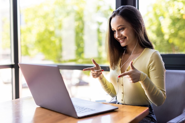 Foto gratuita bella donna freelance che parla in una videoconferenza on line e laptop in un desktop da ufficio o a casa