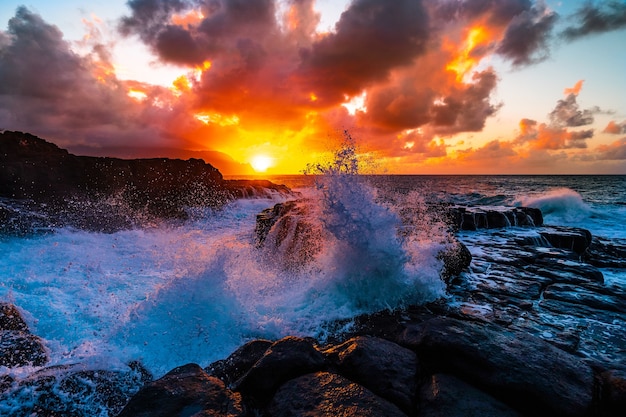 Foto gratuita splendido scenario di formazioni rocciose in riva al mare a queens bath, kauai, hawaii al tramonto