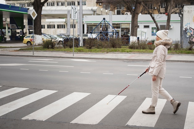 Foto gratuita persona cieca che cammina per la città con un bastone cieco