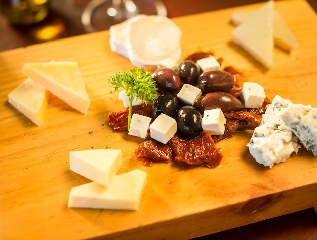 Foto gratuita piatto di formaggi con un bicchiere di vino rosso