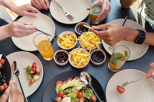 Foto gratuita mani ravvicinate che tengono cibo e forchette