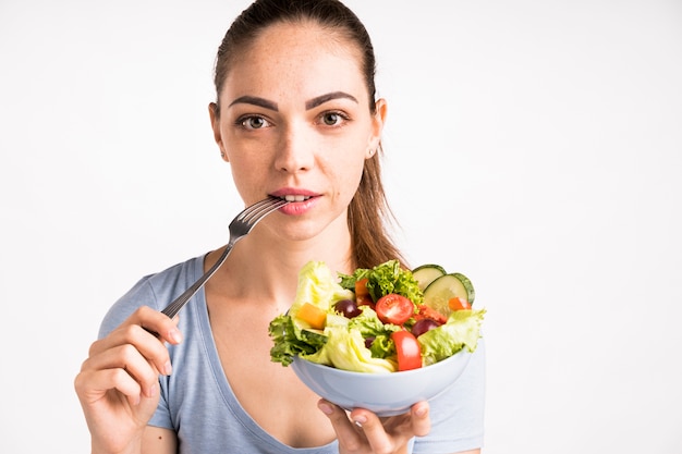 Foto gratuita ritratto del primo piano della donna che tiene un'insalata