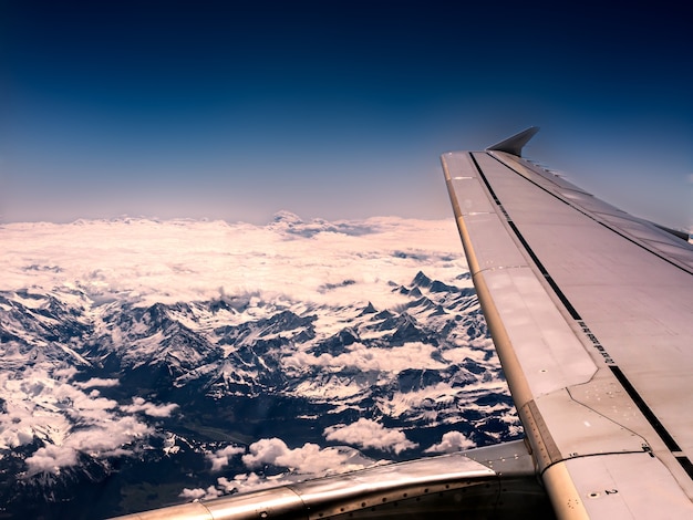 Foto gratuita primo piano di un'ala di aeroplano e montagne