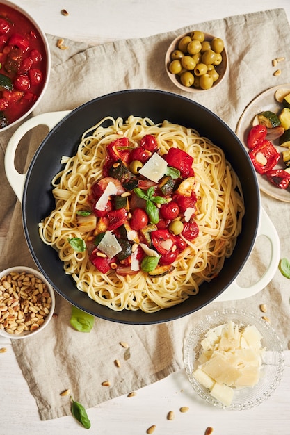 Foto gratuita pasta colorata con verdure e ingredienti su un tavolo bianco