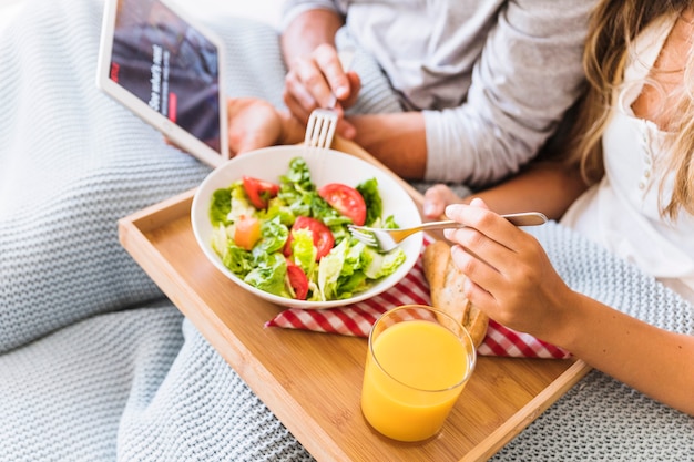 Foto gratuita crop coppia godendo insalata mentre si guarda la serie tv