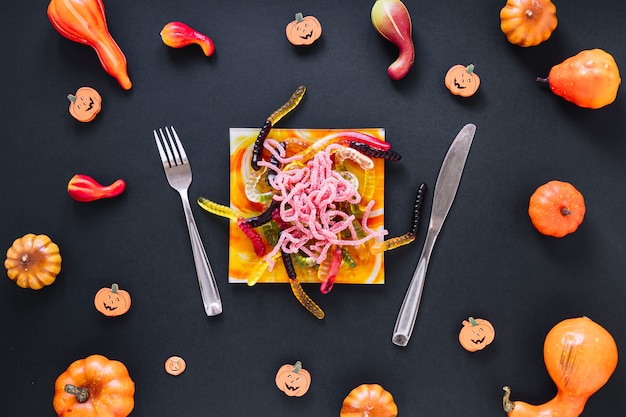 Foto gratuita decorativo cibo di halloween circondato da zucche