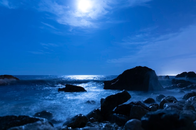 Foto gratuita luna piena nel cielo sopra l'acqua di mare