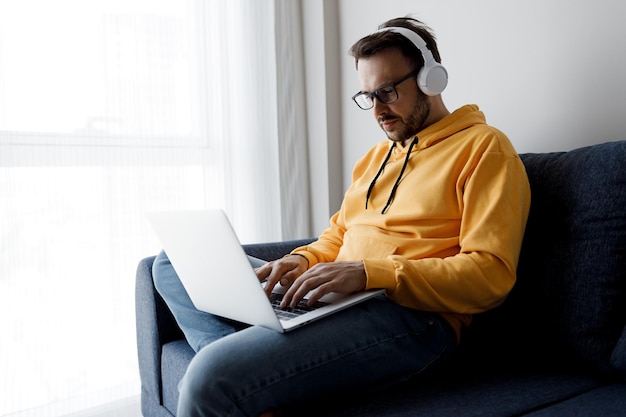 Foto gratuita bell'uomo che lavora con il laptop a casa