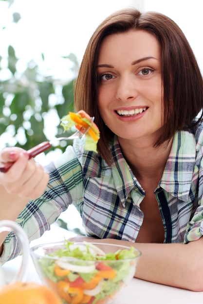 Foto gratuita donna felice con la ciotola di insalata fresca