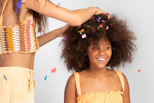 Foto gratuita bambini che festeggiano con i coriandoli da vicino