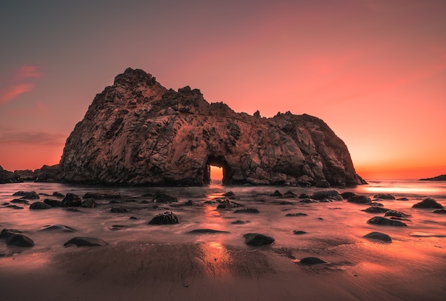 Foto gratuita grande scogliera sulla spiaggia di pfeiffer negli stati uniti durante il tramonto