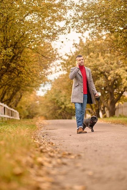 Foto gratuita uomo che cammina con un cane in un parco