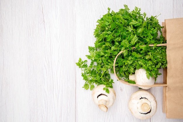 Foto gratuita vista dall'alto di un fascio di broccoli di funghi verdi freschi in un cesto su sfondo bianco