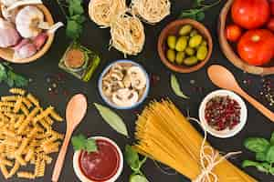 Foto gratuita una vista aerea di pasta cruda con ingredienti su sfondo nero