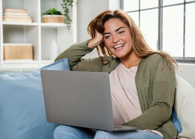 Foto gratuita donna del ritratto a casa con il computer portatile