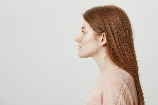 Foto gratuita profilo di una bella donna rossa con le lentiggini guardando a sinistra