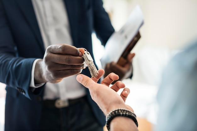 Foto gratuita agente immobiliare consegnando la chiave di casa a un cliente