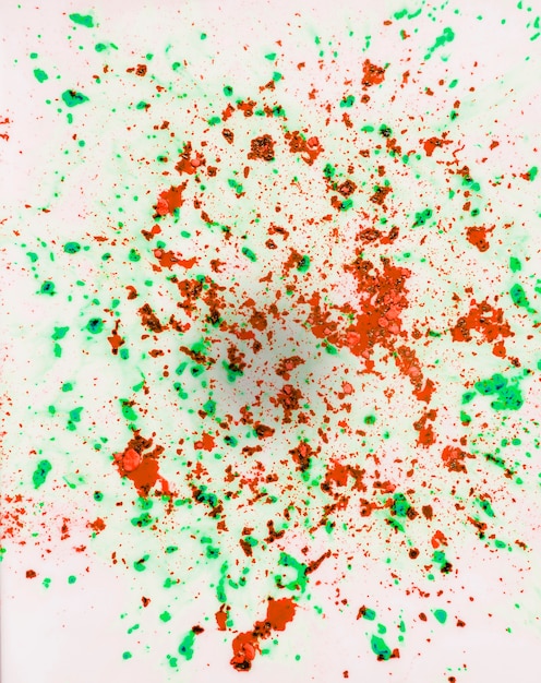 Foto gratuita polvere di colore rosso e verde di holi sul contesto di superficie bianco