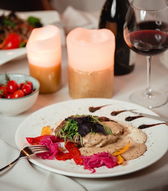 Foto gratuita insalata con erbe e salsa cremosa con un bicchiere di vino rosso.