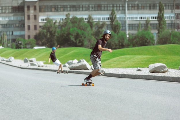 Foto gratuita skateboarder che fanno un trucco in strada nella giornata di sole