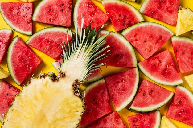 Foto gratuita concetto estivo. concettuale. fetta insalata gustosa di ananas con fette di anguria su sfondo vibrante brillante giallo con lettere in legno estate. lay lay.