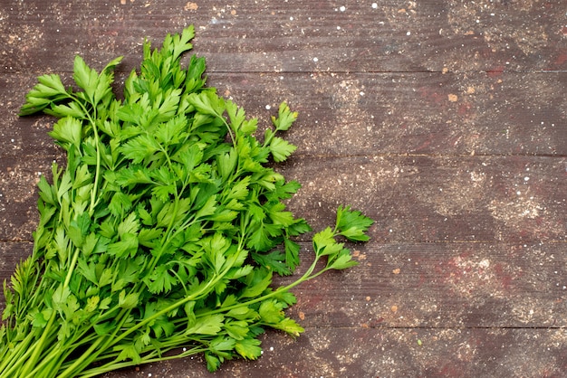 Foto gratuita greenies verdi di vista superiore freschi e maturi sulla foglia marrone e verde dell'insalata