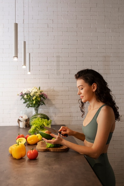 Foto gratuita donna che si disconnette digitale a casa preparando una sana insalata di verdure