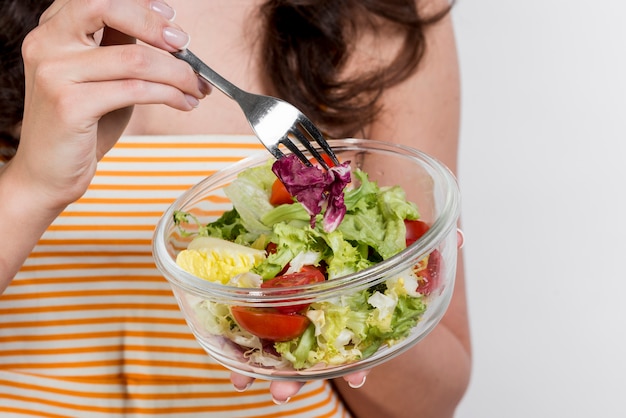 Foto gratuita donna che mangia un'insalata di lattuga