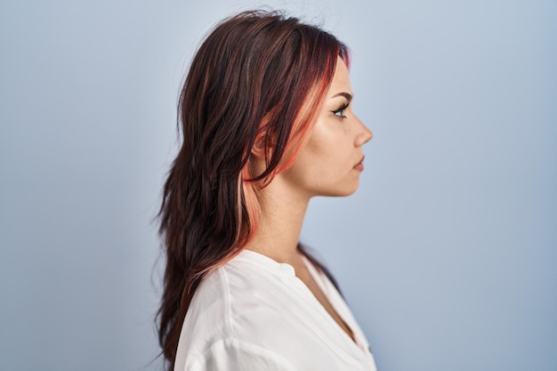 Foto gratuita giovane donna caucasica che indossa una camicia bianca casual su sfondo isolato guardando al lato relax profilo posa con viso naturale e sorriso fiducioso