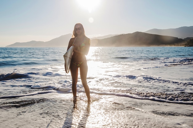 Foto gratuita ragazza posa con la tavola da surf