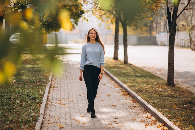 Foto gratuita giovane donna in maglione blu nella sosta di autunno