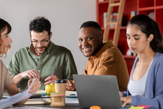 Photo gratuite camarades de classe apprenant et souriant pendant la session d'étude