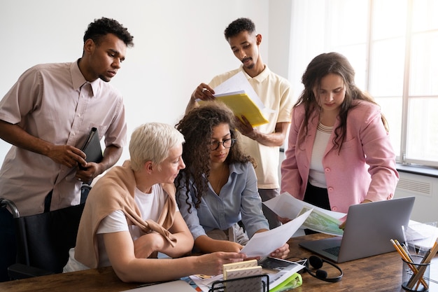 Photo gratuite collègues de plan moyen travaillant ensemble