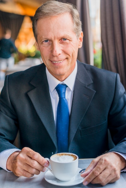 Photo gratuite gros plan d'un homme d'affaires mature heureux avec une tasse de café