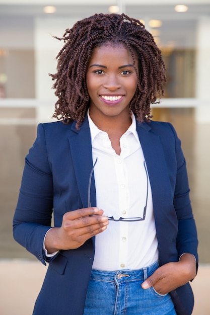 Photo gratuite heureux agent de vente réussi posant près du bureau