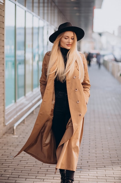 Photo gratuite jeune jolie femme au chapeau noir et manteau beige marchant par mall